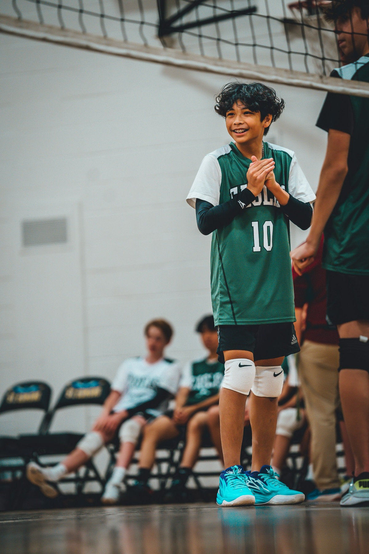 Volleyball player number 10 smiling and clapping between points