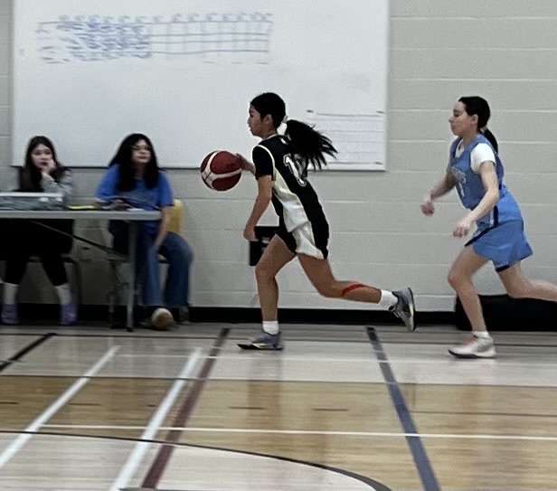 Girls basketball player pushing the ball up the floor on a fast break